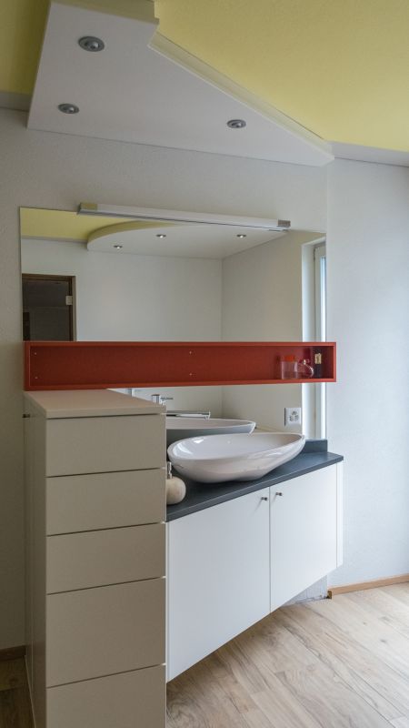 Lavabounterbau und Schubladenstock mit Schieferabdeckung. Wirkungsvolles Detail ist der Baldachin mit stimmungsvollem Licht (dimmbar). Für starkes Licht zum Rasieren und Schminken kann die Leuchtstoffröhre zugeschaltet werden.
